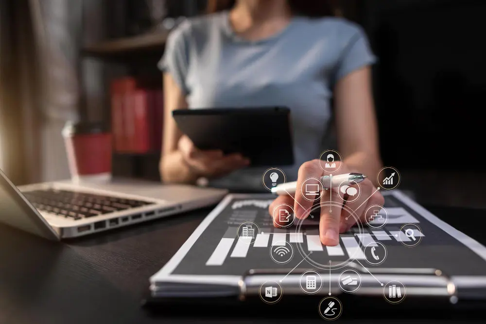 Mão de mulher apertando tela de tablet com ícones ilustrados de integração ERP e e-commerce flutuando 